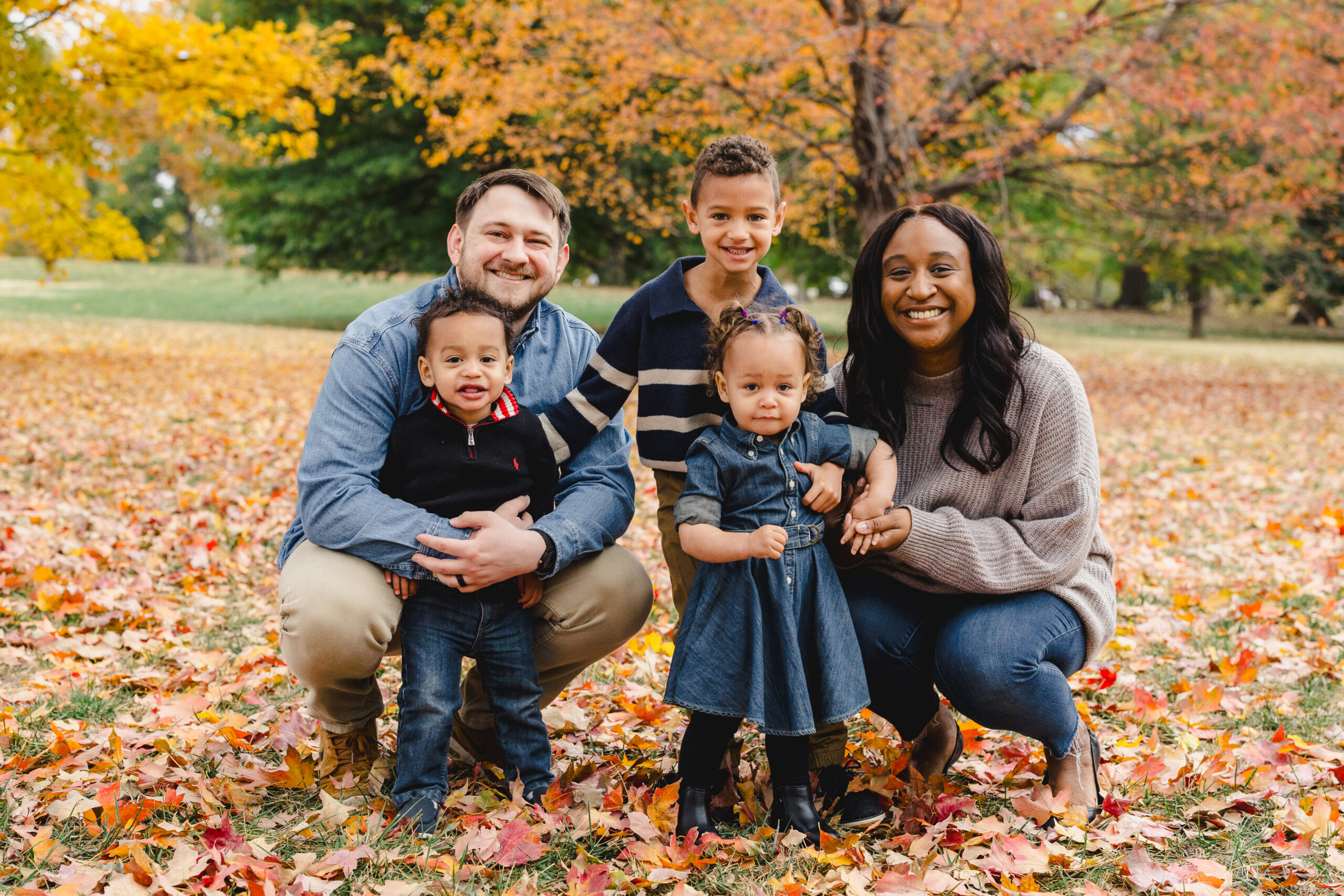 a family taking fall family photos in loose park in the fall foliage 