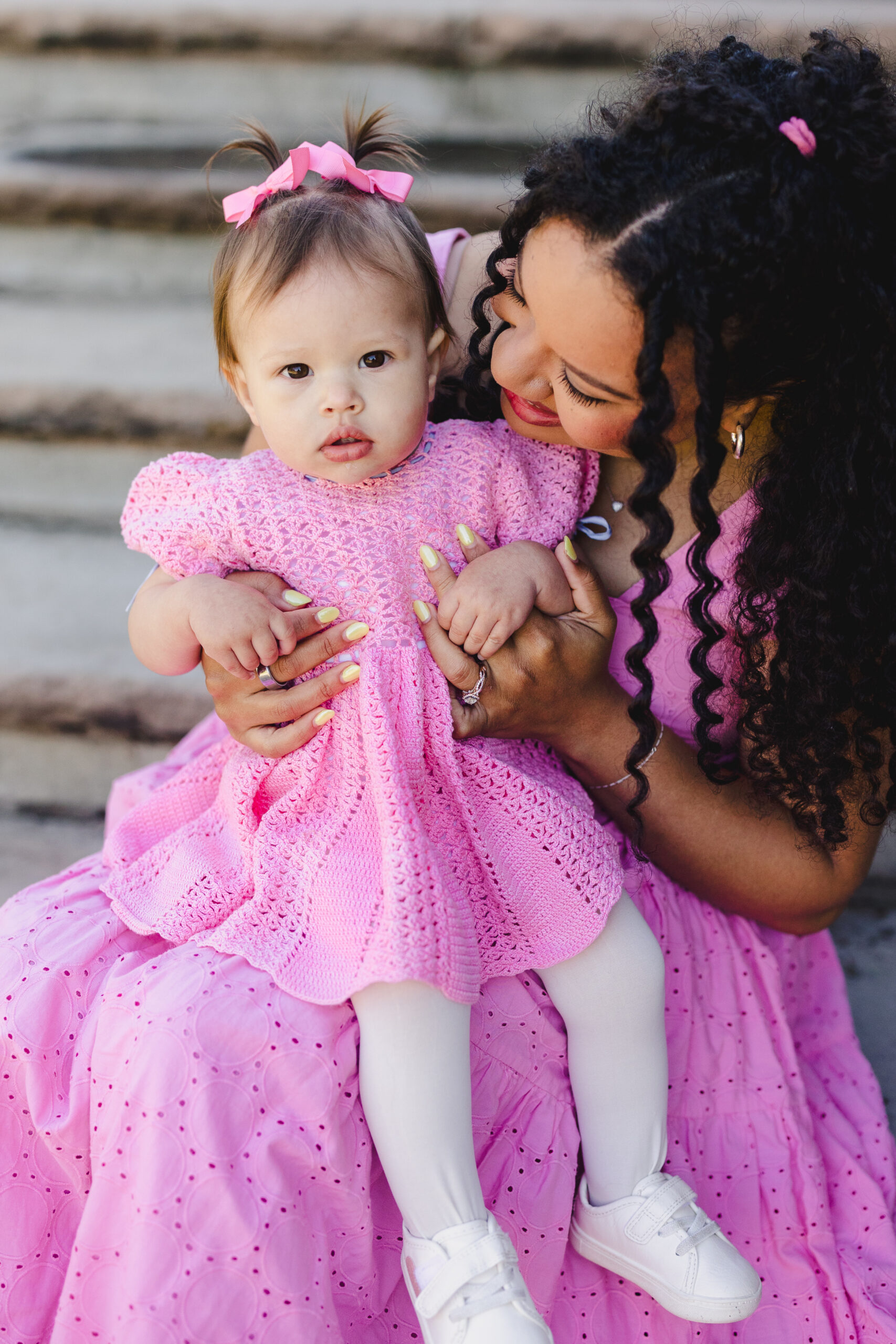 a mother holding her daughter and sitting on steps 