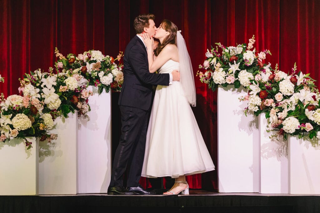First Kiss in the grand theatre at Madrid Theatre Kansas City wedding venue