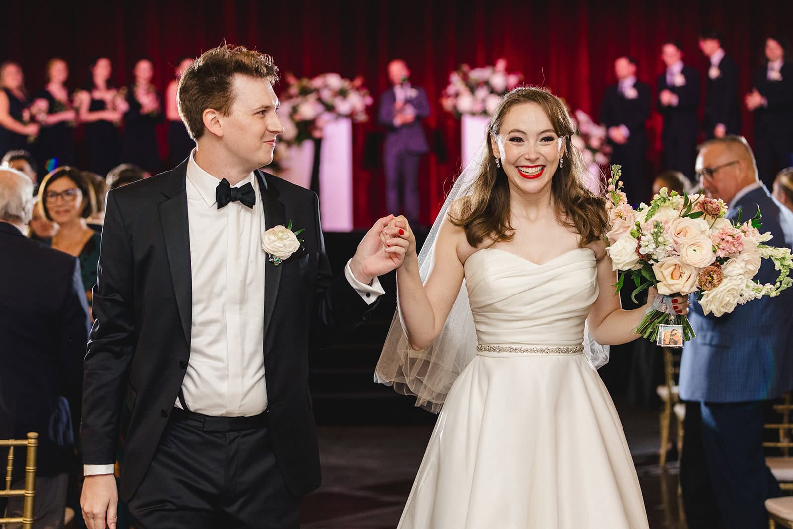 A bride and groom walk back down the aisle at Madrid Theatre in Kansas City