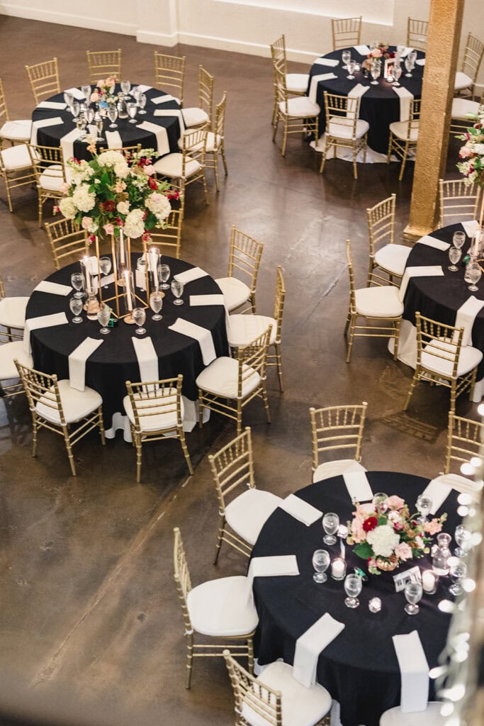 A reception set up at Madrid Theatre in Kansas City featuring beautiful white and gold florals and chairs.