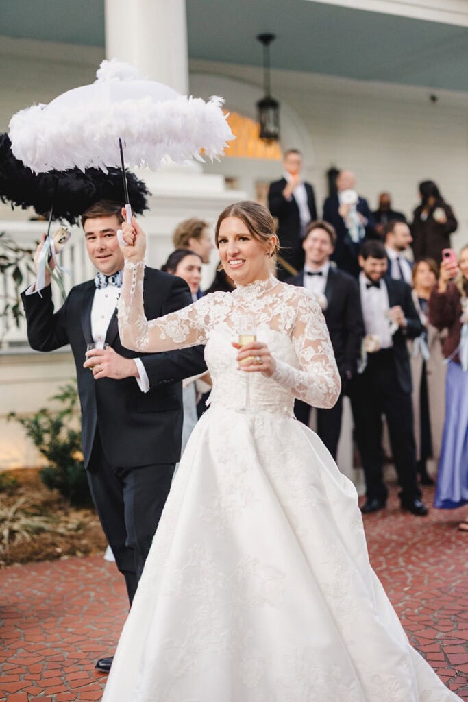 A bride and groom starting the second line to their reception in front of the Admiral's House in Charleston, South Carolina